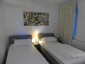 2 Betten in einem kleinen Zimmer mit einem Bild an der Wand in der Unterkunft Rez de jardin au calme et proche mer in Mandelieu-la-Napoule