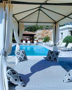 una cama bajo un dosel junto a una piscina en Villa Asteri, views, private, pool heating on request, 30 mins from Paphos, en Pafos