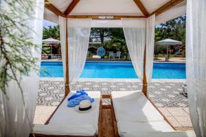 a tent with a hat on a table next to a pool at Hotel Summery in Lixouri