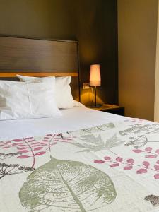 a bed in a hotel room with a bedspread with flowers on it at Hotel Don Pablo in Villasana de Mena