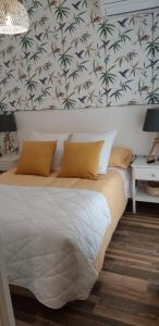 a bedroom with a large bed with a wall with palm trees at Apartamentos A Poniente in Villanueva de la Concepción