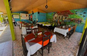 a restaurant with tables and chairs and a painting on the wall at Hotel El Icaco Tortuguero in Tortuguero