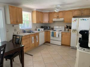 a kitchen with wooden cabinets and a white refrigerator at Hidden quiet gem close to everything!!! in Sarasota
