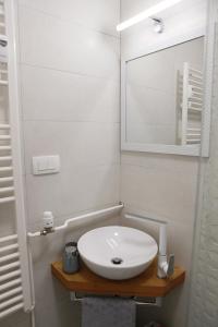 uma casa de banho com um lavatório branco e um espelho. em Apartman RIVERVIEW em Karlovac