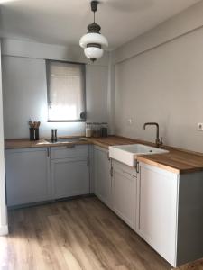 a kitchen with white cabinets and a sink at Agradable apartamento en el Pantano de San Juan in San Martín de Valdeiglesias +7 photos
