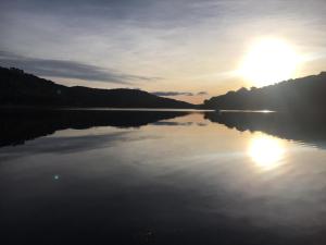 a view of a lake with the sun setting at Agradable apartamento en el Pantano de San Juan in San Martín de Valdeiglesias