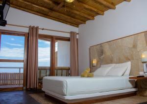 a bedroom with a white bed with a teddy bear on it at El Mirador de Vichayito in Vichayito