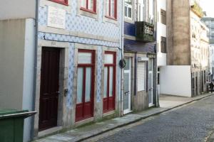une rue vide avec des portes rouges sur un bâtiment dans l'établissement Artury Porto, à Porto