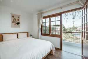 a bedroom with a bed and a large window at Pea Home - Nhà Đậu Homestay in Hiếu Nhơn
