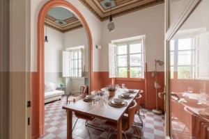 a dining room with a table and a large mirror at iFlat Sunny and Colorful Esquilino Apartment in Rome