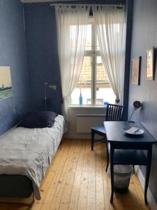 マリエスタードにあるSTF Hostel Mariestadのベッドルーム1室(ベッド1台、テーブル、窓付)