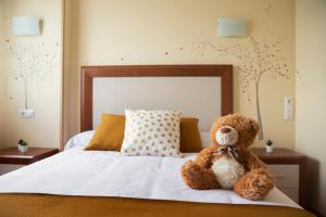 a teddy bear sitting on top of a bed at HOSTAL LA GRANJA ** in Palazuelos de Eresma
