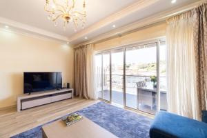 a living room with a tv and a large window at Histórical City Center Penthouse Albufeira in Albufeira