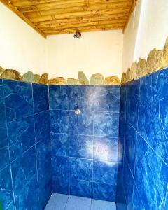 baño con paredes de azulejos azules y azulejos azules en Refugio Nidos del Condor Cocora, en Salento