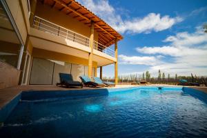 a swimming pool in front of a house with two chairs at Chaglasian Wine & Suites in San Rafael