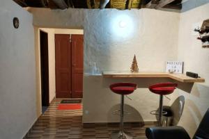 a bar with two red stools in a room at Mirador Valle del Tomine - Cabaña vista al embalse in Guatavita