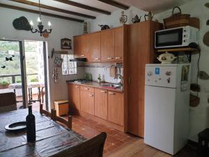 a kitchen with wooden cabinets and a white refrigerator at Casa Canaria Tejeda in Tejeda