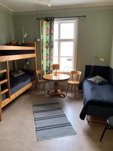 een kamer met 2 stapelbedden en een tafel en een bed bij STF Hostel Mariestad in Mariestad