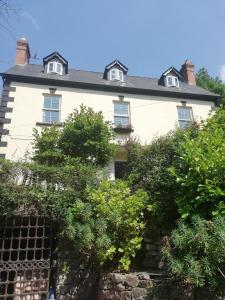 a white house with trees in front of it at Family Suite, Inglewood House in Newland