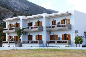 a building with a palm tree in front of it at Idomeneas Apartments in Sougia