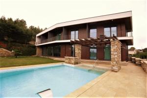 a house with a swimming pool in front of a building at O Casario in Mirandela