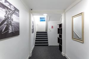 a hallway with stairs and pictures on the walls at Darlington Town Centre Apartments free parking and Wi-Fi in Darlington