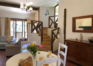 a living room with a table and a staircase at Gîtes de Montcabirol - Malepère in La Bastide-de-Bousignac +22 photos