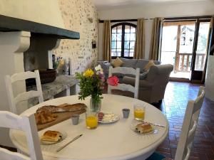 una mesa con comida y flores en la sala de estar en Malepère en La Bastide-de-Bousignac
