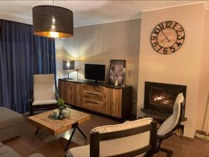 a living room with a fireplace and a clock on the wall at Enjoy Durbuy 2 in Durbuy
