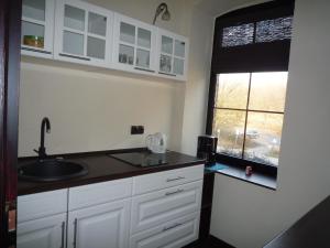 a kitchen with white cabinets and a sink and a window at Alte Post Linderhofe (Extertal) in Extertal