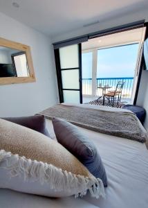 two beds in a room with a view of the ocean at Exclusif Appartement en 1er Ligne, Vue Imprenable, Piscine, Parking Privé à Playa Mucha Vista, Alicante in El Campello