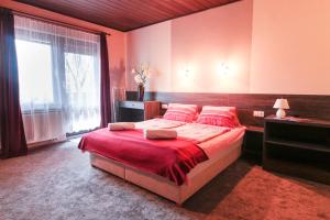 ein Schlafzimmer mit einem großen Bett und einem großen Fenster in der Unterkunft Emi Vendégház in Balatonszemes