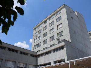 a tall gray building with a blue sky in the background at Hotel Don Gregorio in Cartago +29 photos