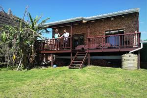 two people standing on a deck of a house at 2 Bedroom Guest Suite at A-frame Glengariff Beach in Glen Eden