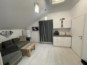 ein kleines Wohnzimmer mit einem Sofa und einem Tisch in der Unterkunft Jolie Luxury Apartments II in Timişoara