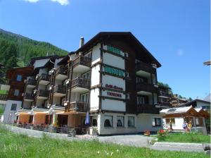 a large building with balconies on the side of it at Hotel Europa Guest House in Saas-Fee