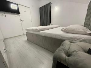 een slaapkamer met 2 bedden en een deur met een raam bij Jolie Luxury Apartments II in Timişoara