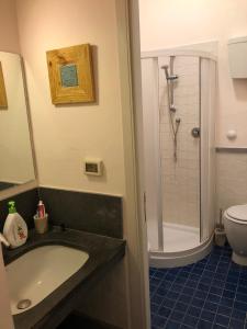a bathroom with a sink and a shower and a toilet at Dammuso Bacio Pantesco in Scauri