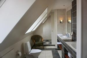 a bathroom with a toilet and a sink and a staircase at Old Roses Guesthouse in Broager