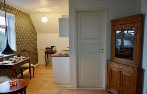 eine Küche mit einer Tür und einem Tisch in einem Zimmer in der Unterkunft Old Roses Guesthouse in Broager