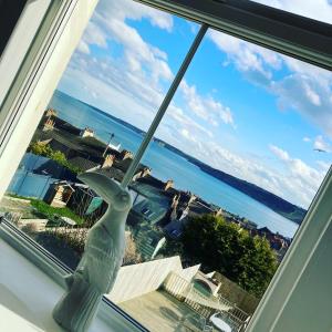 een raam met uitzicht op de oceaan en een vaas bij Seascape Seaview Apartment hot tub hire subject to availability in Scarborough