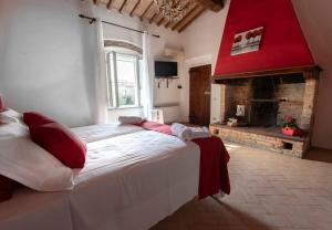 a bedroom with a large bed and a fireplace at Agriturismo Le Biricoccole in Vada