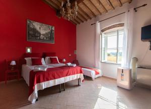 een rode slaapkamer met 2 bedden en een raam bij Agriturismo Le Biricoccole in Vada