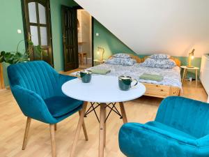 VászolyにあるVazul Vendégházのベッドルーム1室(ベッド1台、青い椅子2脚、テーブル付)
