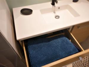 a drawer under a white bathroom sink with a sink at Charmant T2 bord de mer in Anglet +40 photos