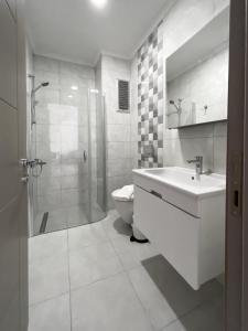 La salle de bains est pourvue de toilettes, d'un lavabo et d'une douche. dans l'établissement Azize Palas Apart Otel, à Izmir