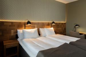 a bedroom with a large bed with white sheets and pillows at Nybro Stora Hotellet in Nybro