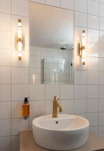 a white bathroom with a sink and a mirror at Nybro Stora Hotellet in Nybro
