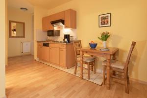 eine Küche mit einem Holztisch sowie einem Tisch und Stühlen in der Unterkunft Ferienwohnung #20 Am Neuensiener See - Seedorf in Sellin