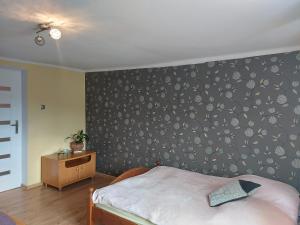 ein Schlafzimmer mit einer mit Blumentapete bedeckten Wand in der Unterkunft Sopatka in Lutowiska